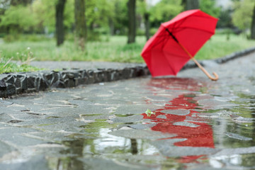 Open umbrella on city street, closeup. Rainy day