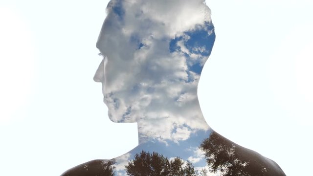 Portrait of pensive man and clouds in the sky - Double exposition