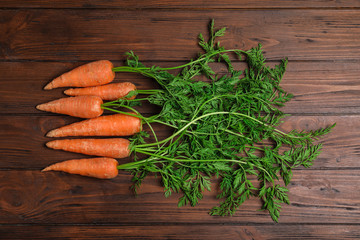 Fresh ripe carrots on wooden background, top view