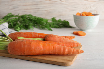 Cutting board with carrots on table. Space for text