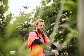 A handsome young man riding a bicycle in the park