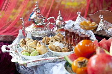 Foto op Canvas Oriental tea tray and cookies symbolising Moroccan hospitality, Islamic holidays food with decoration. Ramadan kareem. Eid mubarak. Oriental hospitality concept. Tea glasses and pot, traditional delig © Inna