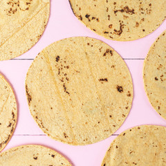 Mexican corn tortillas on pink background