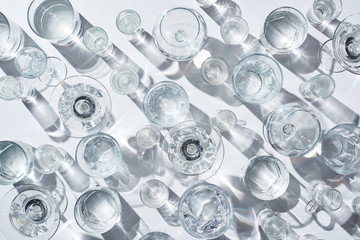 top view of transparent glasses with clear water on white background