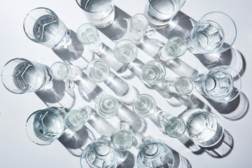 top view of transparent glasses with clear water on white surface