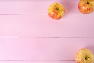 Set of red and yellow apples on pink background
