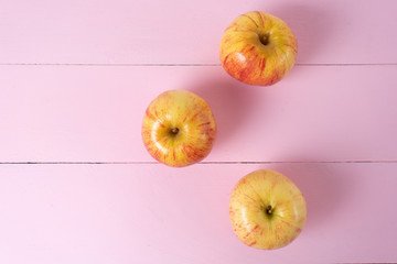 Set of red and yellow apples on pink background