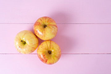 Set of red and yellow apples on pink background
