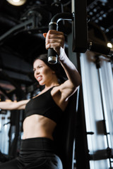Obraz na płótnie Canvas selective focus of sportswoman exercising on training apparatus in gym