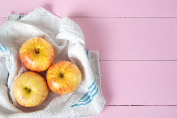 Set of red and yellow apples on pink background