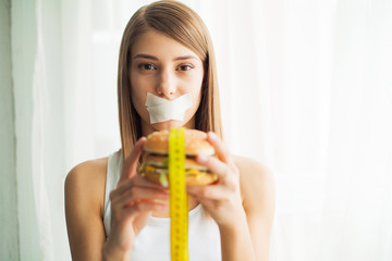 Diet. Young woman preventing her to eat junk food. Healthy eating concept