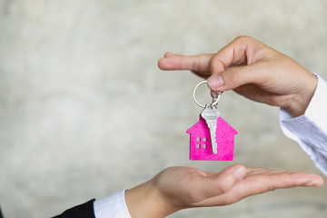 real estate agent holding house key to his client after signing contract agreement in office,concept for real estate, renting property