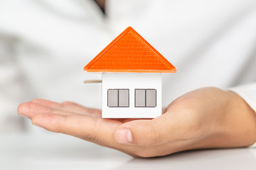 Your new house, woman hands holding a  model house. Mortgage property insurance dream moving home and real estate concept