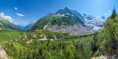 Fototapeta na wymiar Panoramic view of a picturesque mountain valley. Summer greens and glaciers. North Caucasus, Russia.