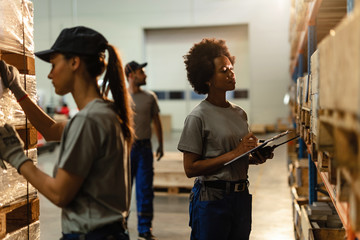 Female African American worker checking stock in a warehouse.