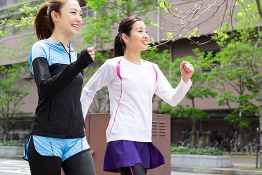 市街地をウォーキングする女性2人 - Powered by Adobe