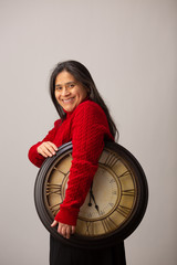 Smiling Hispanic Woman Holds Clock And Smiles To Camera