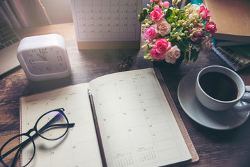 Planner and Concept.Desktop Calender 2022, cup of coffee place on office desk, working space. Notebook for Planner to make timetable agenda, appointment and agenda each date, month and year