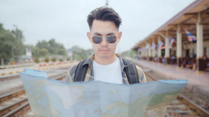 Traveler Asian man direction and looking on location map while spending holiday trip and waiting...