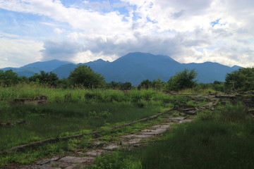 Fantastic greek landscape with ancient stone road and Olympic mountains and clouds on the background, Greece