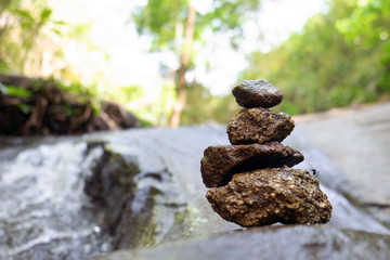 Four stones are arranged vertically and have flowing through the forest.