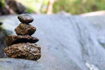 Four stones are arranged vertically and have flowing through the forest.