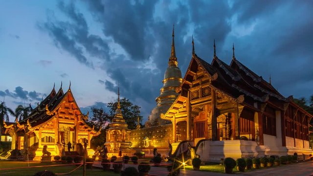 timelapse Wat Phra Singh buddhist temple, crowds of people swarm in front of the setting sun
