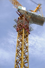 Naklejka premium Tower crane soars into blue sky