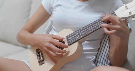 Fototapeta na wymiar Woman play ukulele at home