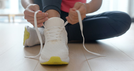 Naklejka premium Woman wearing sport shoes at home