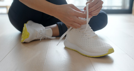 Woman wearing sport shoes at home - obrazy, fototapety, plakaty