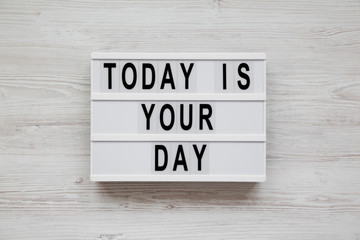 Modern board with 'Today is your day' words on a white wooden surface, top view. Flat lay, overhead, from above. Close-up.