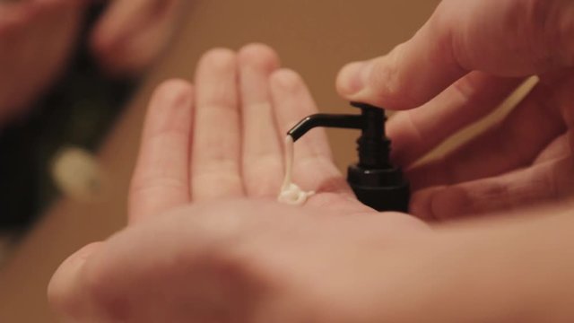 Hand cream is squeezed out of a pump.