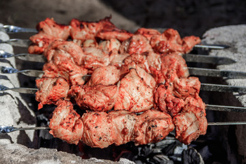 pork shish kebab on skewers. marinated meat. meat kebab. skewers on skewers. cooking on fire.