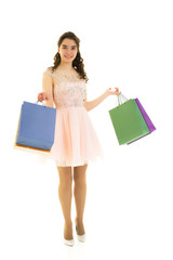 Teenager girl shopping in a store with large paper bags.