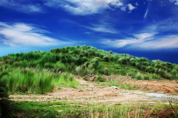 Small grass mountain with colorful cloud sky