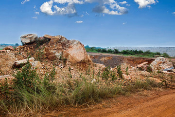 small rock hill near the road with blue sky