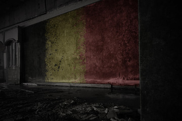 painted flag of belgium on the dirty old wall in an abandoned ruined house.