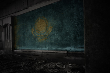 painted flag of kazakhstan on the dirty old wall in an abandoned ruined house.