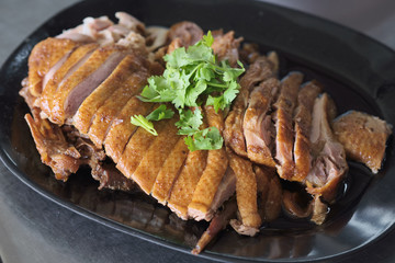 Duck breast on black plate with dumplings sauce .chinese style dish.