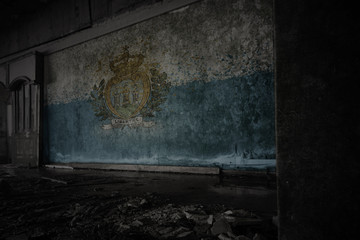Fototapeta na wymiar painted flag of san marino on the dirty old wall in an abandoned ruined house.
