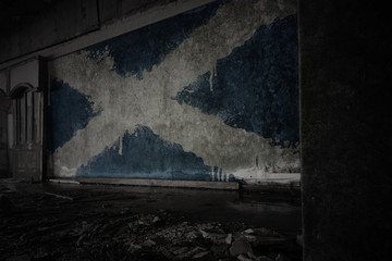 painted flag of scotland on the dirty old wall in an abandoned ruined house.