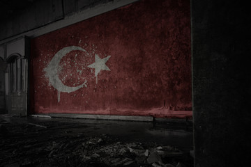 painted flag of turkey on the dirty old wall in an abandoned ruined house.