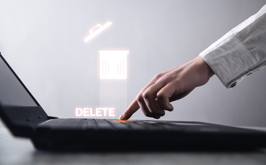 Hand typing laptop keyboard. Delete