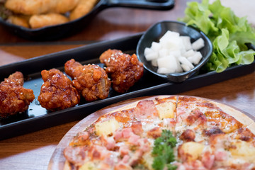 Fried chicken drumlets served with pizza