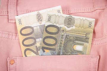 Currencies euro in pocket of pink pants. Finance and banking