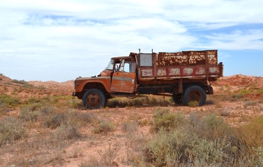 Old rusty abandoned tip truck in the outback desert landscape near Coober Pedy in Australia