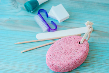 Pedicure accessories with nail polish on wooden background