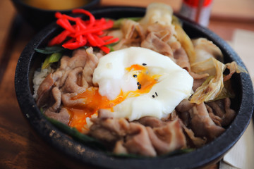 Japanese food Gyudon Japanese beef on rice bowl topped with egg on wooden table