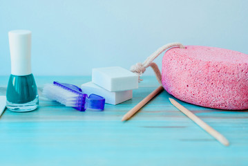 Pedicure accessories with nail polish on wooden background